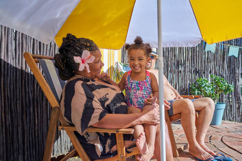 Portrait cute granddaughter with grandmother at summer poolside - CAIF32273