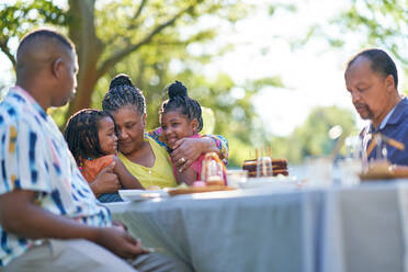 Multigenerational family celebrating birthday at patio table - CAIF32284