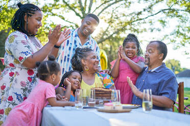 Glückliche Mehrgenerationenfamilie feiert Geburtstag am Terrassentisch - CAIF32292