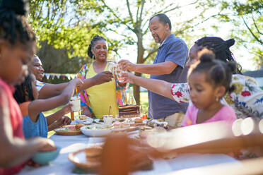 Mehrgenerationenfamilie feiert Geburtstag am sommerlichen Terrassentisch - CAIF32299