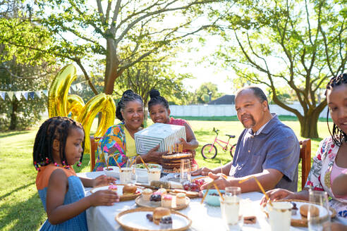 Mehrgenerationenfamilie feiert Geburtstag im sommerlichen Hinterhof - CAIF32314