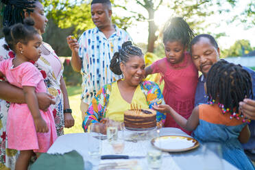 Multigenerational family celebrating birthday at patio table - CAIF32317