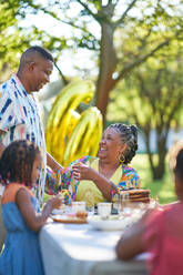 Happy multigenerational family celebrating birthday at patio table - CAIF32319