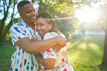 Porträt glückliches Paar umarmt in sonnigen Sommer Park - CAIF32320