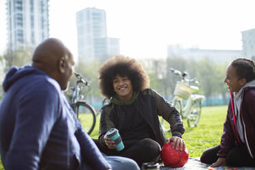 Vater und Kinder unterhalten sich im sonnigen Stadtpark - CAIF32327