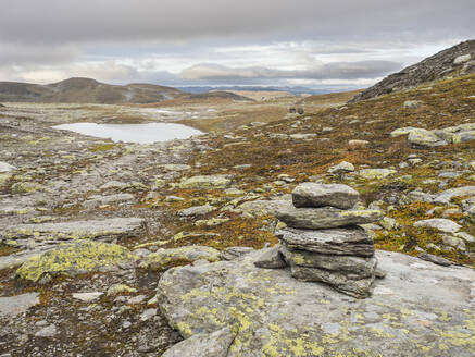 Kleiner Steinhaufen auf der Hardangervidda-Hochebene mit See im Hintergrund - HUSF00231