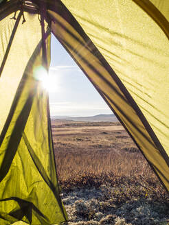 Das Innere eines Zeltes im Hardangervidda-Nationalpark mit der aufgehenden Sonne im Hintergrund - HUSF00239