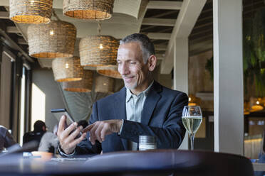 Lächelnder Geschäftsmann mit Tablet-PC im Restaurant - EIF02858