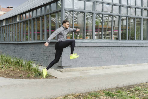 Active sportsman jumping on footpath - SEAF00252