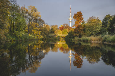 Deutschland, Hamburg, Herbstbäume spiegeln sich auf der Oberfläche des glitzernden Sees im Park der Wallanlagen - KEBF02105