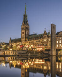 Germany, Hamburg, Christmas market in front of Hamburg City Hall reflecting in Inner Alster Lake at dusk - KEBF02110