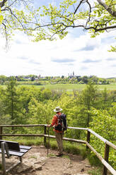 Wanderer mit Blick auf das Salvatorianerkloster Steinfeld vom Eifelsteig in der Eifel, Nordrhein-Westfalen, Deutschland - GWF07288