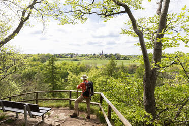 Älterer Wanderer mit Blick auf das Salvatorianerkloster Steinfeld vom Eifelsteig in der Eifel, Nordrhein-Westfalen, Deutschland - GWF07289