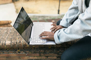 Teenage girl using laptop on wall - JRVF02332