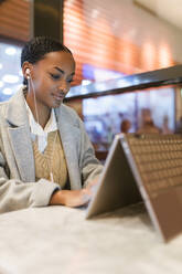 Beautiful girl using touch screen laptop at cafe - JRVF02339