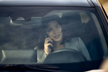 Woman talking on mobile phone in car - ZEDF04302