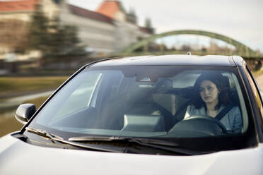 Woman driving electric car on sunny day - ZEDF04328
