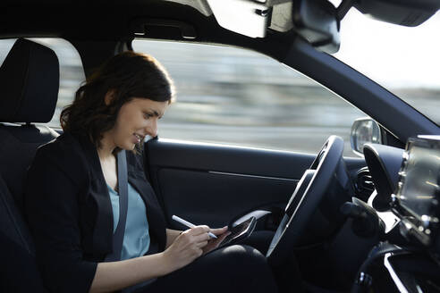 Lächelnde Geschäftsfrau mit Tablet-PC im autonom fahrenden Auto - ZEDF04331