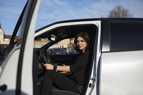 Geschäftsfrau sitzt auf dem Fahrersitz im Auto - ZEDF04342