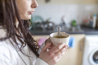 Frau hält Teetasse in der Küche zu Hause - WPEF05631