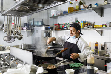 Chefkoch beim Kochen im Wok in der Restaurantküche - IFRF01326