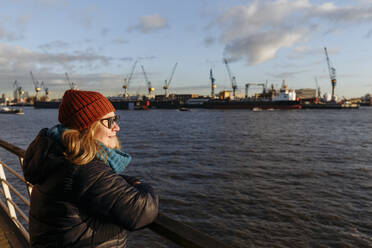 Ältere Frau mit Blick auf die Elbe an einem sonnigen Tag - IHF00741