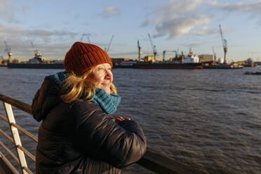 Ältere Frau schaut am Hafen an der Elbe weg - IHF00742