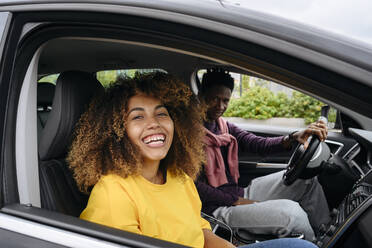 Smiling woman with friend sitting in car - VYF00775