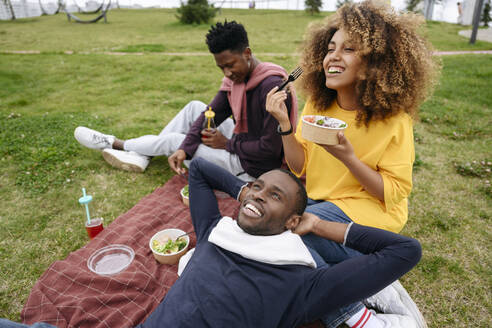 Frau beim Mittagessen mit Freunden im Park beim Picknick - VYF00813