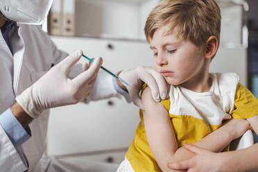Boy getting vaccinated by doctor at center - MFF08382
