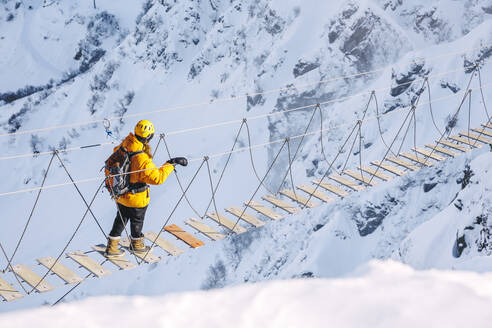 Wanderer auf Seilbrücke über Schneeberge - OMIF00322