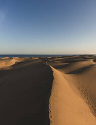 Tourist walking on sand dune at sunset, Grand Canary, Canary Islands, Spain - RSGF00770