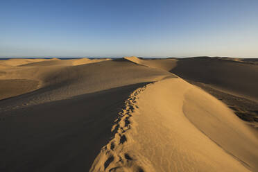 Fußspuren auf Sanddünen unter blauem Himmel, Gran Canaria, Kanarische Inseln, Spanien - RSGF00777