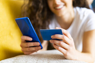 Frau beim Onlinebanking mit Kreditkarte und Smartphone - GIOF14615