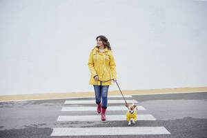 Lächelnde Frau mit Hund auf dem Zebrastreifen - EBBF05141