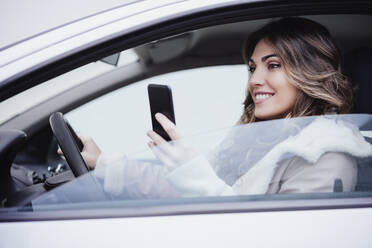 Woman using mobile phone in car - EBBF05190