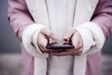 Junge Frau benutzt Smartphone im Park - EBBF05194