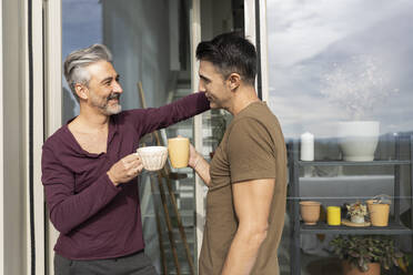 Schwule Männer rösten Kaffeetassen auf dem Balkon - JCCMF04882