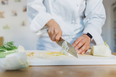 Chef slicing fennel on cutting board at home - MEUF05106