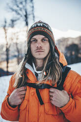 Hiker with knit hat carrying backpack at winter - OMIF00329