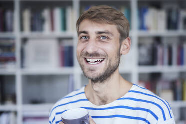 Lächelnder Mann mit Bart hält Kaffeetasse - FMKF07367