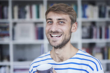 Smiling man with beard holding coffee cup - FMKF07367