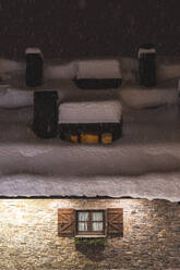 Schneefall vor einem Backsteinhaus bei Nacht - JAQF01029