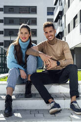 Couple sitting on step in front of building - PGF00959