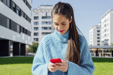 Junge Frau benutzt ein Mobiltelefon in der Stadt - PGF00985