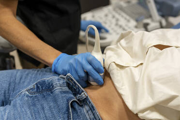 Arzt führt Ultraschalluntersuchung am Bauch eines Patienten durch - DLTSF02527