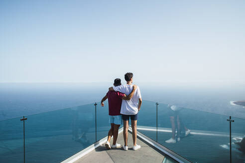 Junge Freunde, die sich in den Armen liegen und auf das Meer blicken, von Mirador Del Balcon, Gran Canaria, Kanarische Inseln, Spanien - RSGF00783