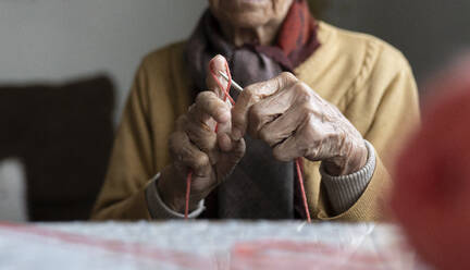 Retired senior woman knitting at home - JCCMF04928