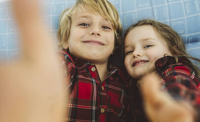 Smiling boy and girl taking selfie at home - JCCMF04955