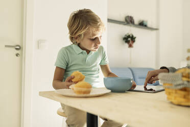 Junge mit Tablet-PC und Muffin zu Hause - JCCMF04962